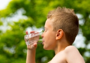 boy drinking water from glass outdoors